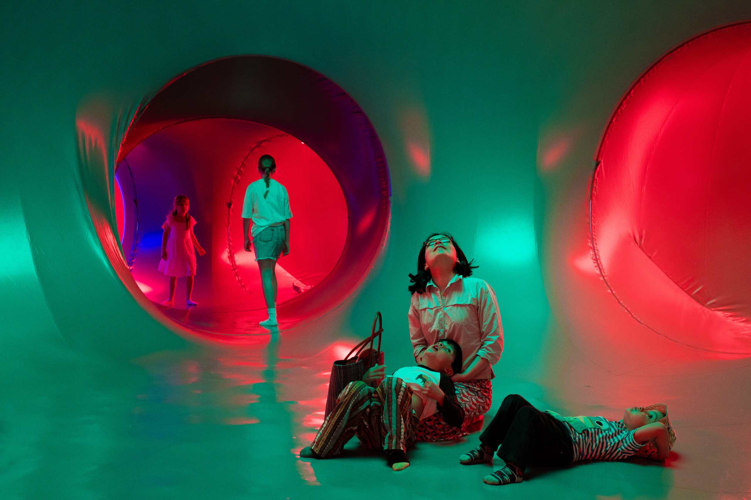 Visitors exploring the colourful interior of Luminarium: Myriad